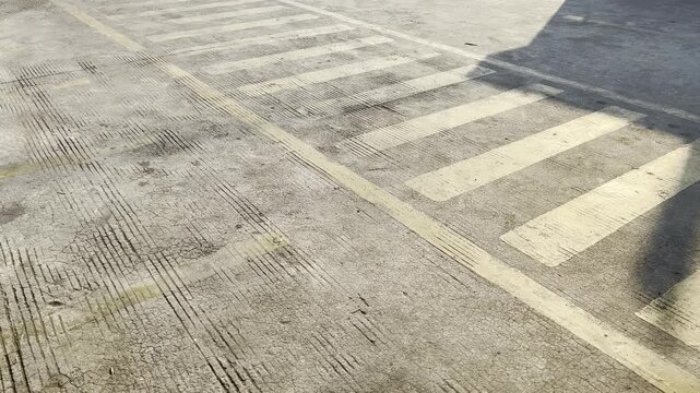 Faded yellow line markings on an empty parking lot surface