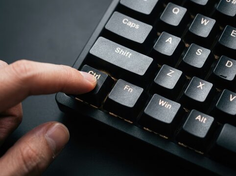 Close up of a hand pressing the Ctrl key on a black mechanical keyboard