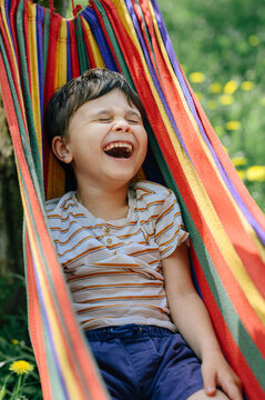 Laughing in a colorful hammock outdoors enjoying summer holiday
