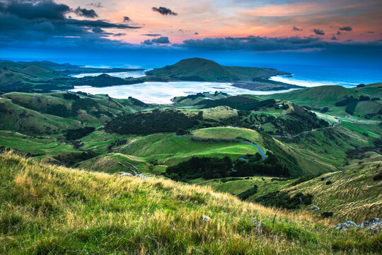Breathtaking panoramic landscape of green rolling hills and valleys beneath a dramatic cloudy sky new zealand