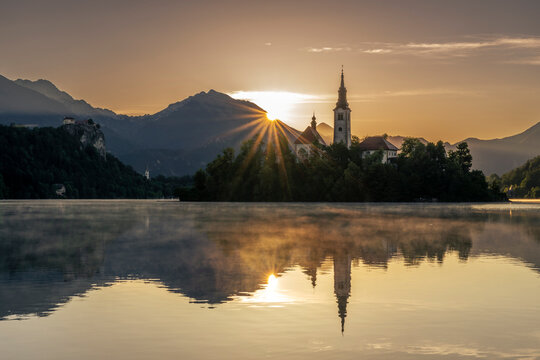 Sun rises over Lake Bled and Pilgrimage church Mari� Himmelfahrt
