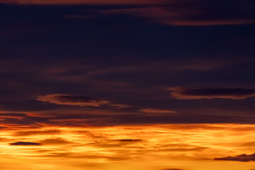Fototapeta premium Dramatic sunset sky with glowing orange clouds and dark moody atmosphere for background