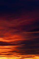 Fototapeta premium Dramatic sunset sky with colorful glowing clouds and deep purple hues for atmospheric background