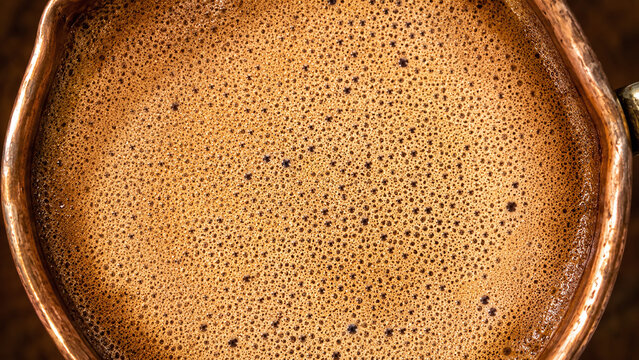 Turkish coffee foam overhead macro close up dense micro-bubble surface warm tan cream copper cezve rim craft beverage food photography culture