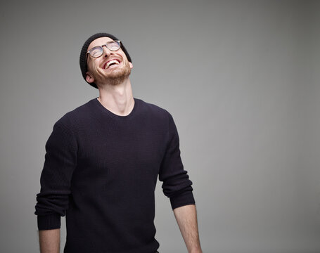 Portrait of laughing man wearing wool cap and glasses
