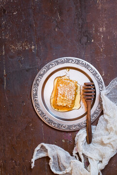honeycomb with honey and honey spoon on tin plate