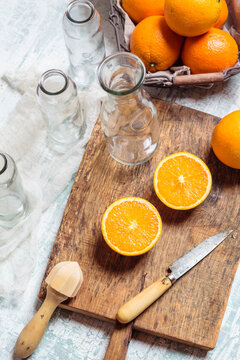 Empty glass bottles and sliced orange on wooden board