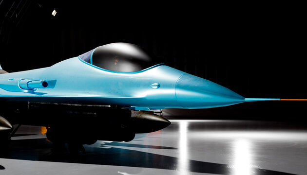 Close up of a blue modern fighter jet in a dark studio