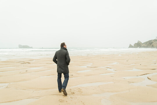 France, Bretagne, Finistere, Crozon peninsula, man walking on the beach