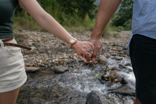 Mixed race couple holding hands close-up on outdoor walk