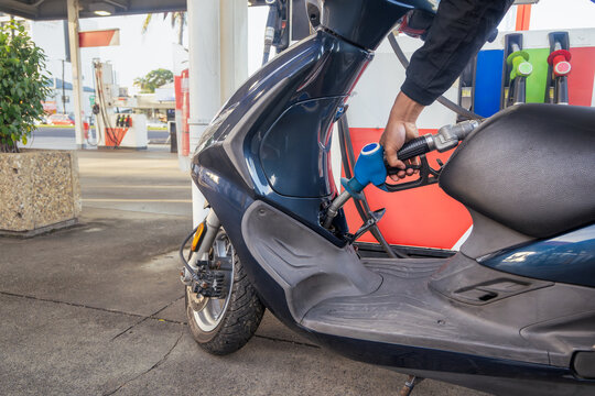 Man refueling his scooter at the servo