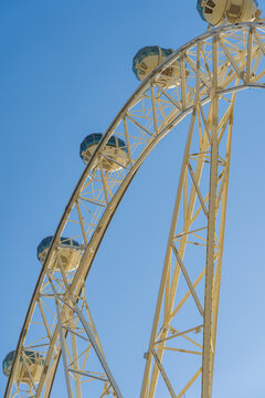 Looking up at gondolas on a segment of a large steel ferris wheel