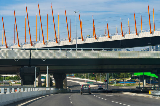 Cars on multi-laned road passing beneath freeway bridges