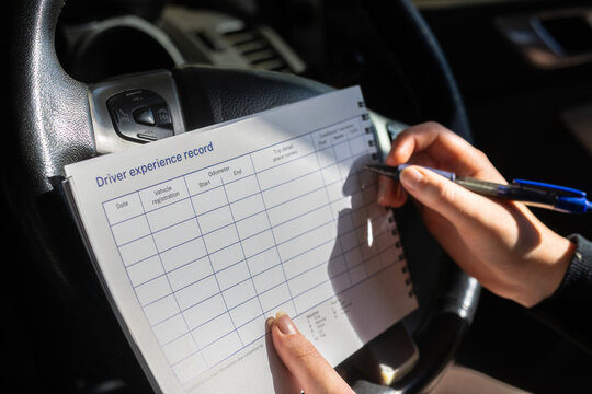 Person sitting in car filling driver experience record form with trip conditions