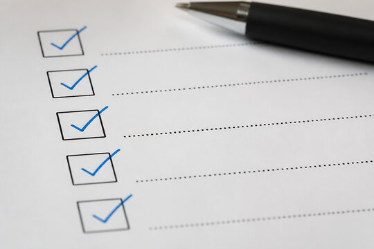 A checklist with checked boxes and a pen on white paper, suggesting task completion or review.