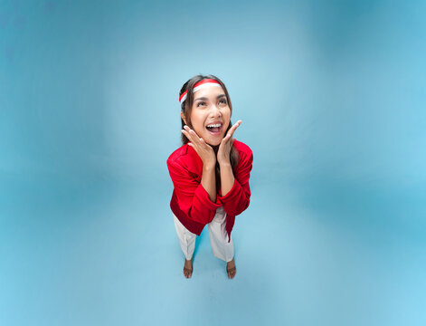 Happy young Indonesian woman is standing and posing smiling to the camera.