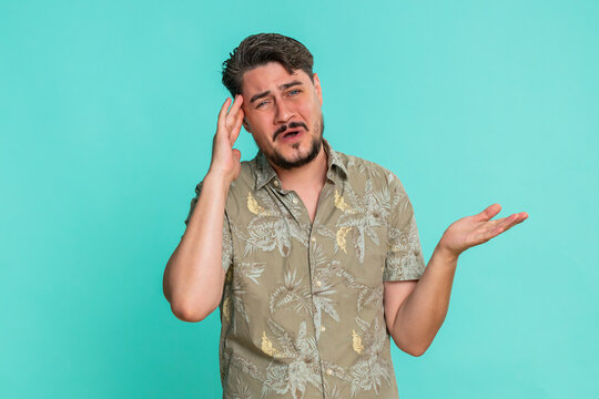 Middle-aged man with nervous expression, hoping for success but reacts with visible disappointment, defeat. Young adult guy shows frustration and emotional failure on blue background