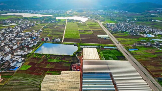 Aerial View of Farmland, Greenhouses, Highway and Rural Town in Mountain Valley