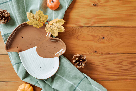 Autumn mushroom shaped plate with leaves on wooden background