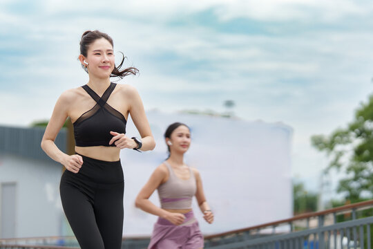 Asian women running outdoors in sportswear for active healthy lifestyle