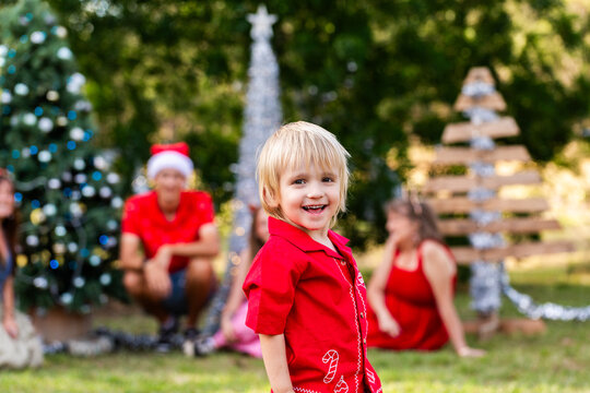 Preschooler boy portrait at Christmas with his family watching