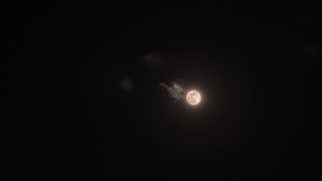 Glowing Full Moon Above Clouds in Dark Night Sky