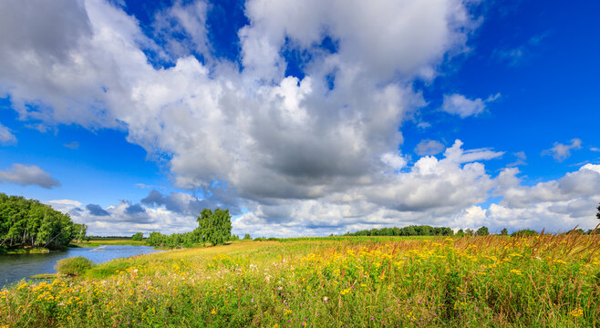Breathtaking natural landscape with river, grassy field, and dramatic sky
