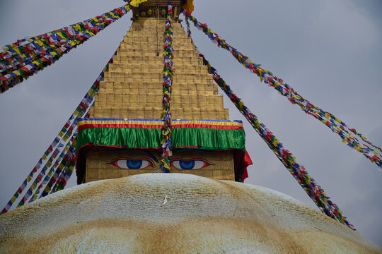 Buddha eyes on Boudhanath Stupa with colorful prayer flags in Kathmandu, Nepal