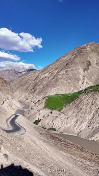 Padum, India : Panoramic footage of high-altitude mountain roads from Padum to Darcha with river flows in Zanskar valley of Ladakh, India surrounded by arid mountain on sunny day