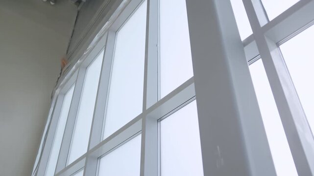 Window structure brings abundant natural light into unfinished commercial space. Top frame area borders raw finish and utility conduits