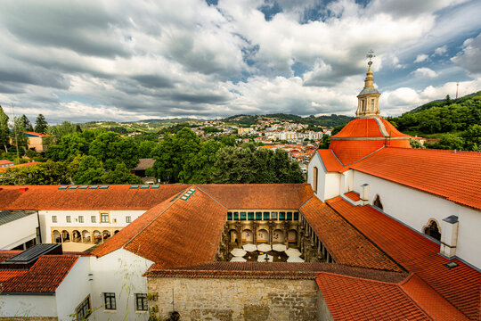 Amarante, Douro Valley, Portugal Amarante, Portugal, viewed from above. Red rooftops stretch across historic buildings. Tower with bell rises above clustered homes. Lush green hills frame the town's s