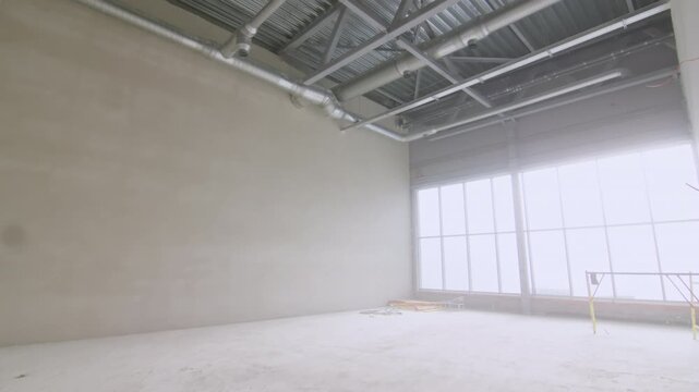 Clean unfinished room shows newly finished walls and prepared floor surface. Modern space stands ready for final flooring processes