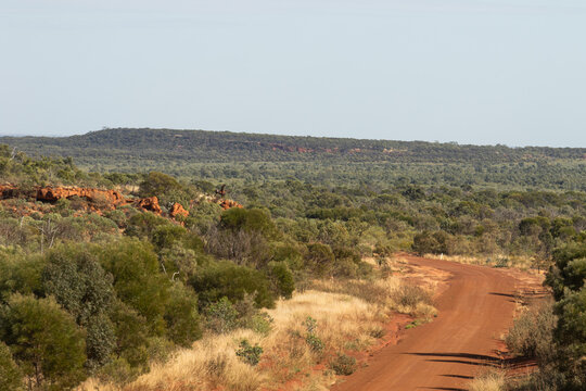 Red dirt road winding around a hill