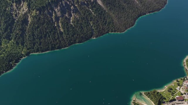 Lake Plansee forested slopes around Reutte district of Tyrol, Austria aerial top-down view