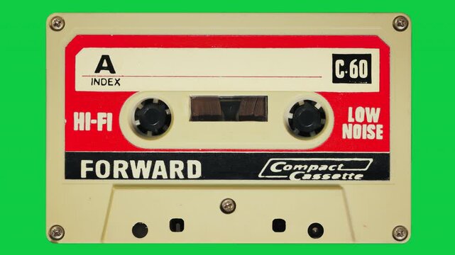 Vintage audio cassette tape playing on green background with alpha channel for seamless loop playback.