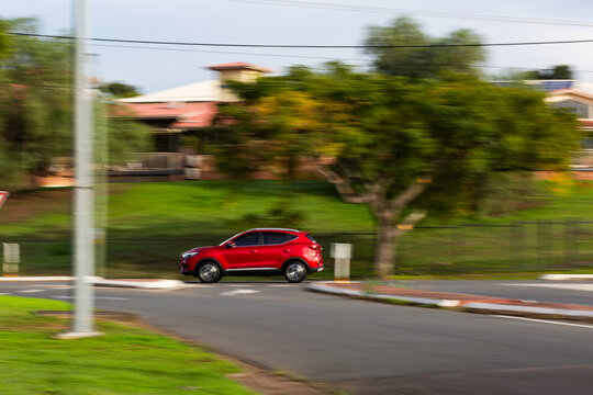 panning motion capture of car traveling down road on morning commute