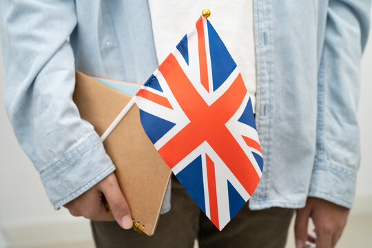 Learn English language, Asian teenage student hold UK flag in course at school.
