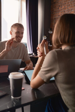 Two people talking with laptops during a casual meeting in a modern office