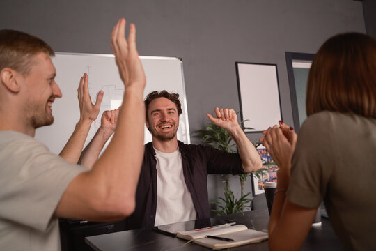 Group of colleagues celebrating success during a productive meeting in the office