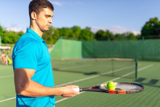 Side profile of a man balancing a tennis ball on his racket