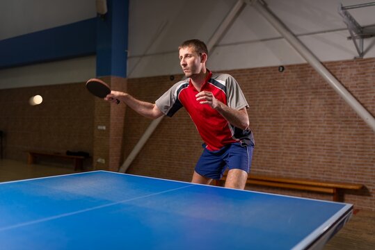 Sportsman striking a ball during a table tennis match