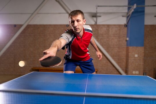 Sportsman striking a ball during a table tennis match