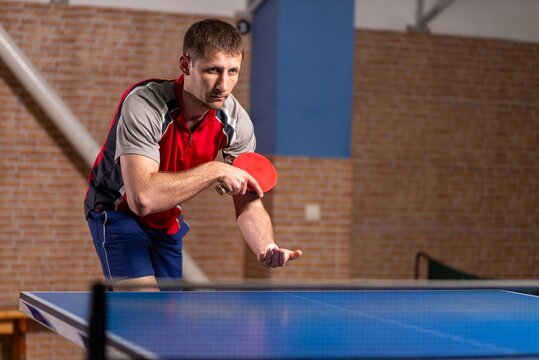 Male athlete holding paddle and ball before serving