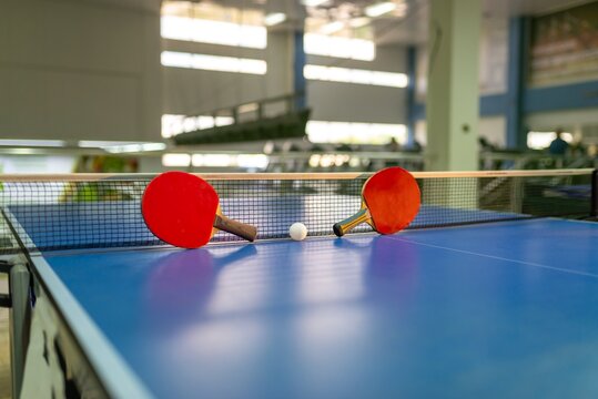 Table tennis paddles resting against the net