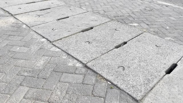Row of Concrete Culvert Slips Cover on Paving Block Urban Sidewalk