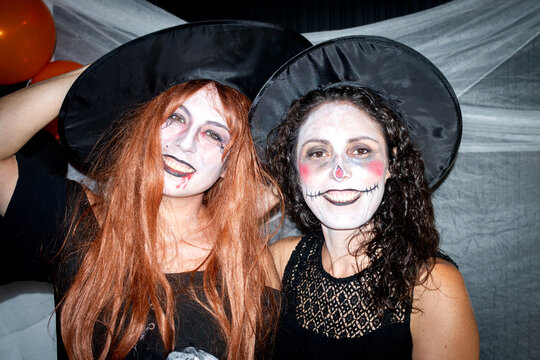 Women in witch costumes posing for Halloween portrait