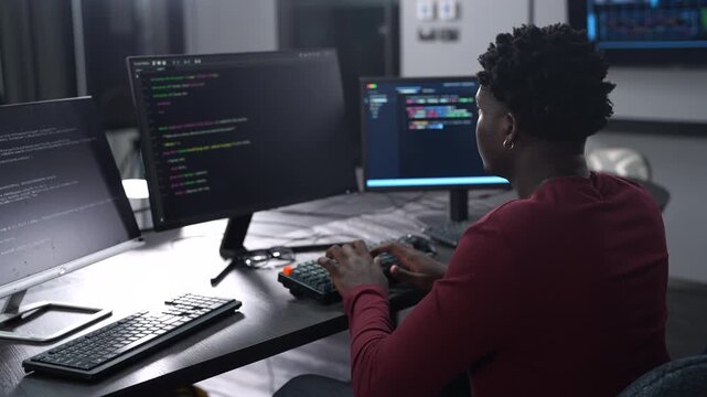 African male programmer coding on computer monitors in modern technology office, Software development, IT business startup, professional software engineer working on smart future digital innovations