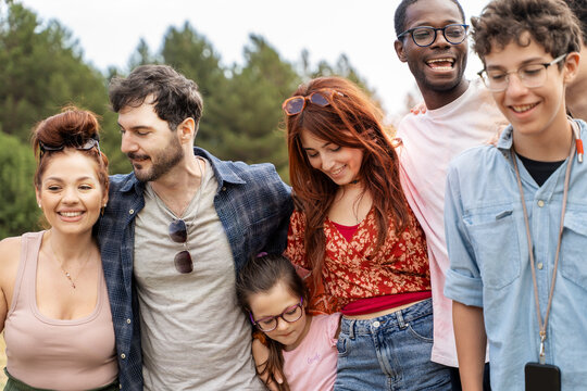 Multicultural people embracing each other outdoors, symbol of belonging, human connection and inclusion