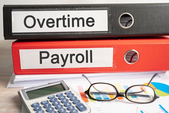 Overtime, Payroll. Binder data finance report business with graph analysis in office.