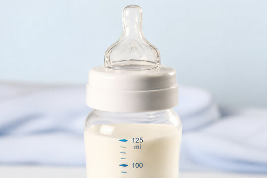 A baby bottle with a measuring scale is displayed against a light blue and white background.